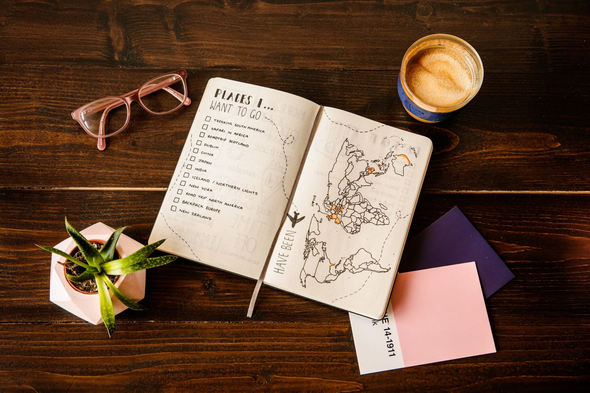 mapa, libreta, lentes, café y otras herramientas para planear viajes
