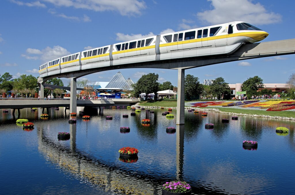 En primavera, la mejor temporada para viajar a Disney World es en mayo. Foto de el monorail pasando sobre una laguna decorada con flores en Epcot