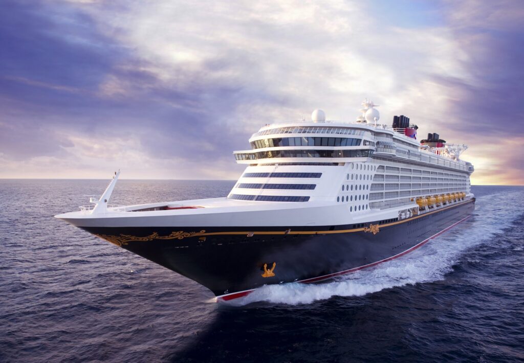 Foto exterior del Disney Dream navegando por el mar en un atardecer nublado. Es uno de los barcos de Disney Cruise Line